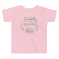Pink t-shirt with 'Fearfully and Wonderfully Made' text and design on a white background